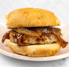 a close up of a sandwich on a plate with meat and onions in the middle