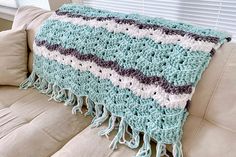 a crocheted blanket sitting on top of a couch