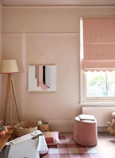 a bedroom with pink walls and furniture in the corner, along with a checkered rug on the floor