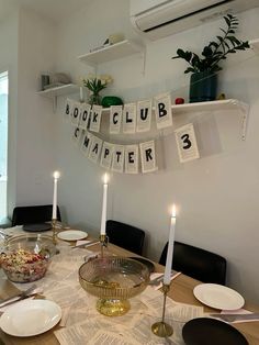 a dining room table with plates and candles on it