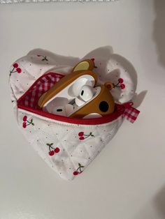 a stuffed animal in a heart shaped pouch