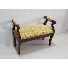 a wooden bench with yellow upholstered fabric on it's seat and back