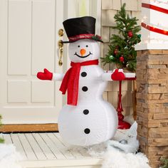 an inflatable snowman standing next to a christmas tree