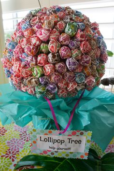 a tree made out of lollipop candies on top of a green plant