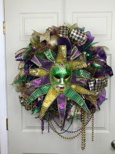 Mardi Gras Wreath, Mardi Gras Jester Wreath, Mardi Gras Decorations, Mardi Gras Wreath for Door, Festive Mardi Gras Wreath with a mask in traditional Mardi Gras colors of purple, gold, and green. This Mardi Gras festive wreath has vibrant colors along with a jester mask.  It is made with Deco mesh on an evergreen wreath frame. This show stopper wreath will reflect the sun making your Wreath sparkle!  All ribbons are wired and can easily be re shaped as needed.  The others items in this wreath co Mardi Gras Jester, Mardi Gras Throws, Mardi Gras Colors, Jester Mask, Wreath For Door, Mardi Gras Wreath, Evergreen Wreath, Mardi Gras Decorations, Wreath Frame