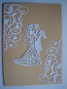 a paper cut wedding card with a bride and groom