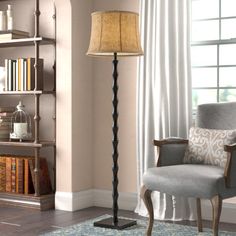 a living room with a chair, lamp and bookshelf