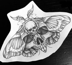 a sticker with a skull and butterfly on it's back side, sitting on top of a table