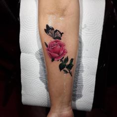 a rose and butterfly tattoo on the leg