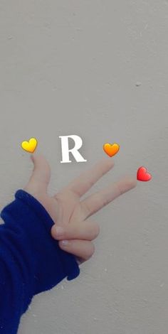 a person's hand with the letter r on it and hearts coming out of their fingers