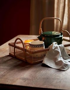 two baskets with food in them sitting on a table next to a tea towel and cup