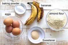 ingredients to make banana bread laid out on a wooden table, including eggs, flour, and bananas