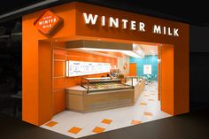 an orange and white store front with the words winter milk on it's side