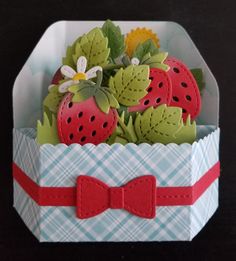 an origami box with strawberries and flowers in it