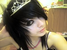 a woman with black hair wearing a tiara