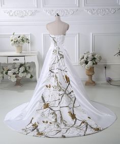 a white wedding dress with gold leaves on it