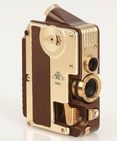 an old fashioned camera sitting on top of a white table