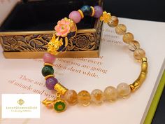 Gift yourself or your loveonce this beautiful Pure Gold Pixiu Bracelet. Pixiu changes color to green, blue, or bluish purple.  *Materials: Au999 Pure Gold, Citrine, , Lavender Jade, Tiger's Eye and  Agate. *Karat: 24K Pure Gold  *Gold Color: Yellow *Gold Weight: Approximately 5.58-5.81g Crystal/Gemstone: Approximately 8.8mm *Pixiu Length: 27.2mm / 1.07 Inch 🧧Pi Xiu has the meaning of bringing in wealth and treasure. Of course, it is capable of warding off evil spirits and bringing good fortune.  🧧the lotus flower symbolizes a very strong meaning of rebirth and/or enlightenment. Lotus flower purifies your heart and  mind that heightens your sense of joy and peace. It is also said to turn bad luck to good luck. 🧧Bamboo, according to Feng Shui attracts good luck and it is the symbol of gro Gold Spiritual Crystal Bracelet For Gift, Gold Spiritual Crystal Bracelet For Wedding, Handmade Gold Crystal Round Bracelet, Handmade Gold Crystal Bracelet, Multicolor Gold Bracelet For Gift, Handmade Gold Crystal Bracelet Gift, Gold Crystal Bangle Bracelet For Gift, Gold Crystal Bracelet For Mother's Day, Mother's Day Gift Gold Crystal Bracelet