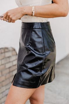 We are loving this cute A-line black leather mini skirt,åÊit's so chic for any date night on the town. We love the black leather fabric it's so chic for any fun outing.åÊThis skirt also features a mini length andåÊside slit detail. Pair this cute skirt with a fun bodysuit and jean jacket for a gorgeous look!åÊ 55% cotton, 45% polyurethane Fabric has no stretch Unlined Size small from waist to hem: 15" Damp wipe, line dry Patterns may vary Materials may have natural variations Colors may vary fro Black Leather Fabric, Black Gold Sunglasses, Black Leather Mini Skirt, Tank Bodysuit, Cute Skirt, Leather Mini Skirt, Black Leather Skirts, Pink Lily