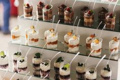 there are many desserts that are on the glass shelves in front of each other