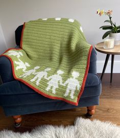 a couch with a blanket on top of it in front of a potted plant