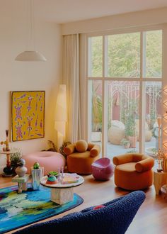 a living room filled with furniture and large windows