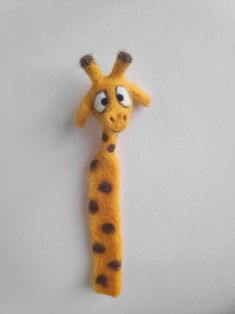 a stuffed giraffe is hanging on the wall with it's eyes wide open