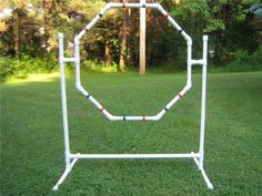 a white metal rack with red, blue and black piping on it in the grass