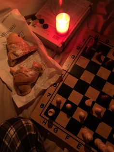 a table topped with pastries next to a candle and checkerboard pattern on it