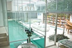 a living room filled with furniture next to a swimming pool