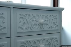 a white cabinet with ornate carvings on it