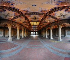 the inside of an ornate building with columns and arches on either side of the walkway