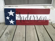 a wooden sign with the word anderson written in black ink on top of an american flag