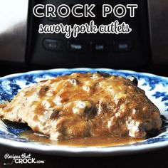 a plate with meat covered in gravy on it next to a crock pot