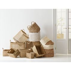 several baskets stacked on top of each other in front of a white wall and window