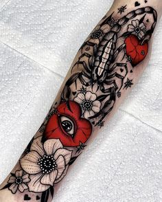 a woman's leg with flowers and an eye tattoo on the left side of her arm