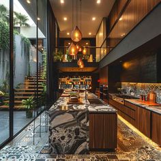 a long bar with marble counter tops and hanging lights in the middle of an open floor plan