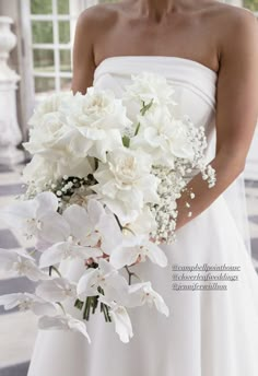 a bride holding a bouquet of white flowers