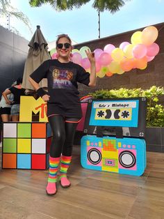 a woman in black shirt and colorful socks standing next to an old school boombox