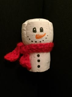 a toilet paper roll snowman with a red scarf around it's neck and nose