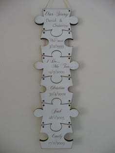 a wooden puzzle piece with the names and date on it, hanging from a wall