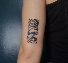 a woman's arm with a zebra print tattoo on the left side of her arm