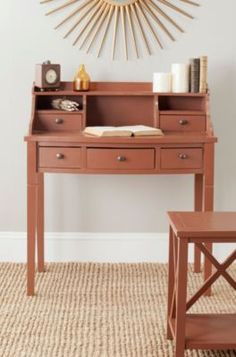 a desk with a clock on the wall above it