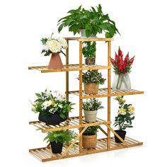 a wooden shelf filled with potted plants on top of each other next to flowers