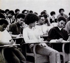 black and white photograph of students sitting in their desks with notebooks on their laps