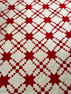 a red and white quilt with stars on it