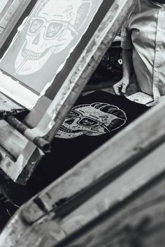 a man standing next to an easel with a skull on it