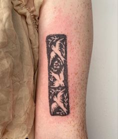 a person with a tattoo on their arm has a black and white photo in the shape of a rectangle