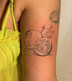 a woman's arm with a pomegranate tattoo on her left side