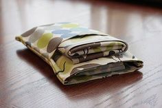 three folded cloths sitting on top of a wooden table